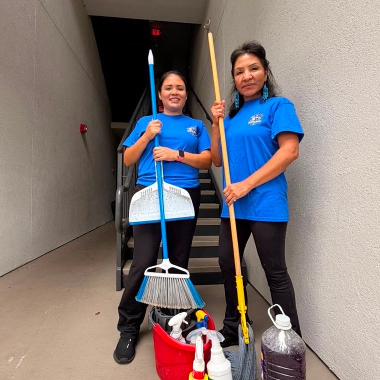 Two White Glove team members with brooms, mop and cleaning supplies